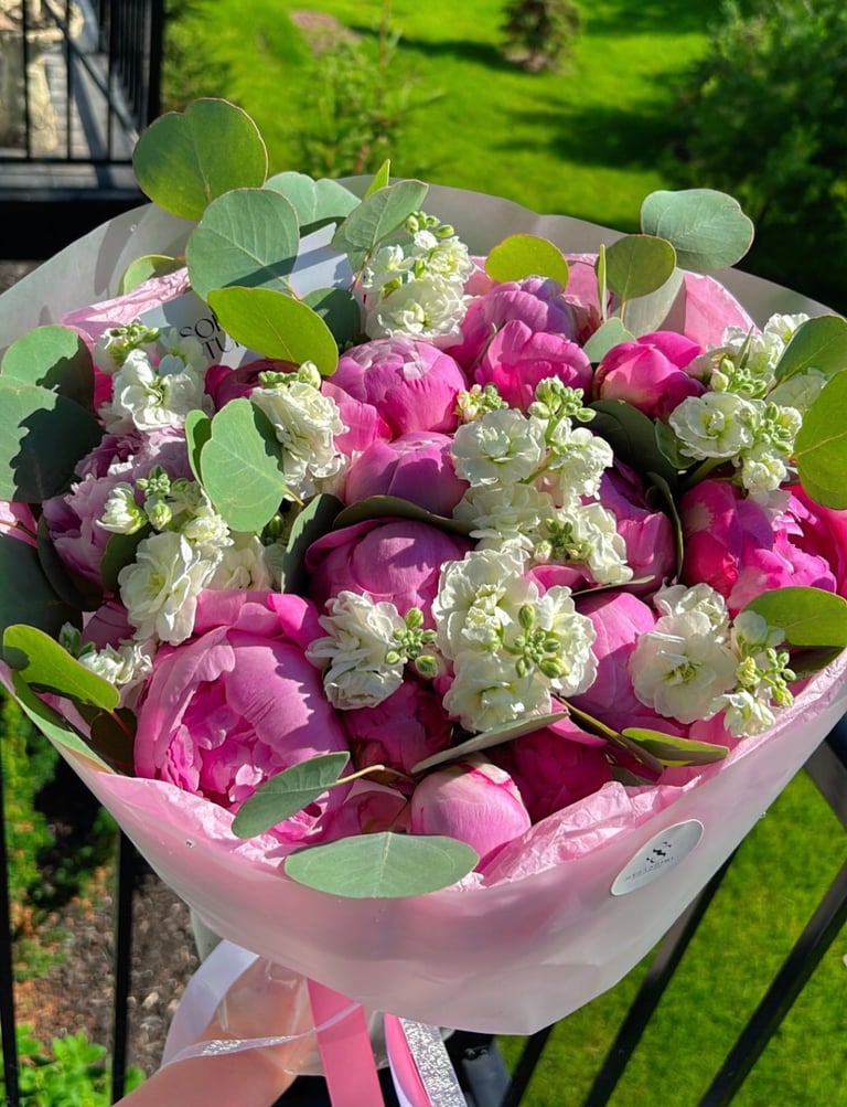 Vibrant bouquet of pink and magenta peonies with white stock flowers